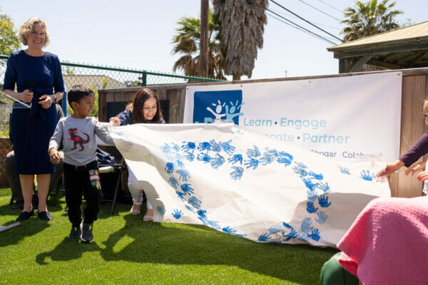 Photo of LEAP preschool students (formerly Islla Vista Youth Projects) helping unveil new logo at May 11 community briefing 